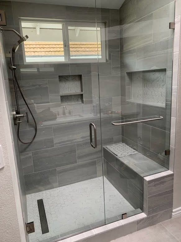 Douche moderne avec carrelage gris et niches intégrées